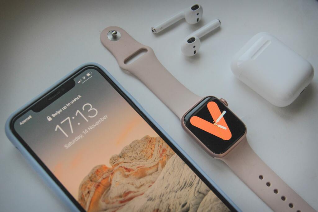 iphone smartwatch and airbuds on desk