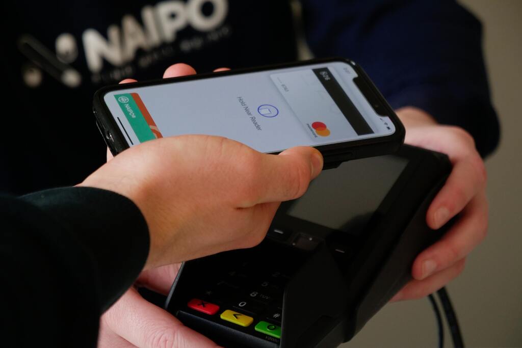 hand holding phone to payment terminal